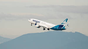 西捷航空飛機在山脈上空起飛