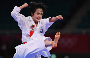 女空手道選手在比賽中身穿白色道服踢腿