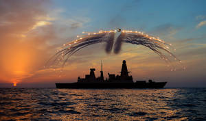 夕陽下的軍艦與直升機在海洋上空釋放照明彈