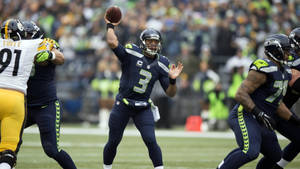 西雅圖海鷹隊四分衛在NFL日間比賽中擲出橄欖球。