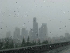 車窗上的雨點，背景是模糊的城市天際線。