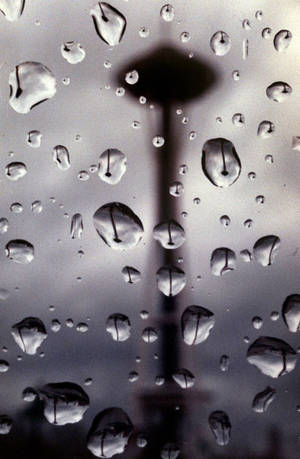 窗戶上的雨滴，背景是模糊的太空針塔輪廓。