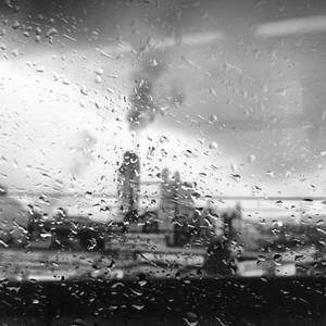 窗戶上的雨滴遮擋了工業煙囪排放煙霧的景象。