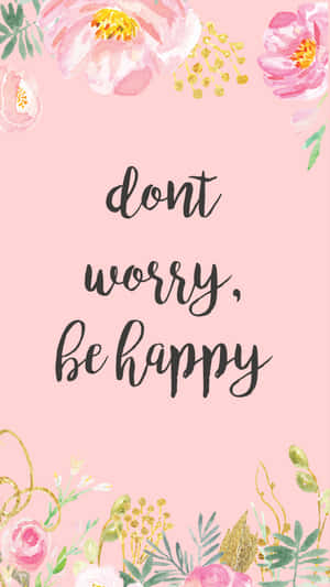 帶有金色點綴和短語 dont worry be happy 的粉紅色花卉壁紙。