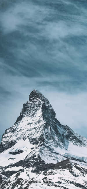 白雪覆蓋的山峰穿過戲劇性的灰色雲層升起。