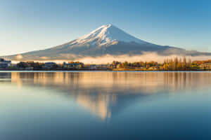富士山倒映在寧靜的湖面上，伴隨著秋樹和晨霧。 — 藍天 壁紙