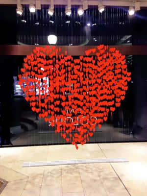 夜晚玻璃店面上懸掛成心形的紅色紙心。 — 可愛情人節gif 壁紙