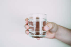 手拿著一杯水在白色背景上