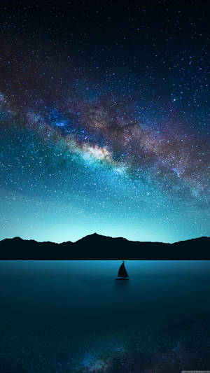 帆船在銀河星空下的寧靜湖面