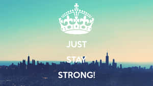 一個皇冠和文字 'Just Stay Strong!' 疊加在日落時分的城市天際線上。