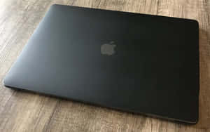 合上的黑色 Apple 手提電腦在木質表面上