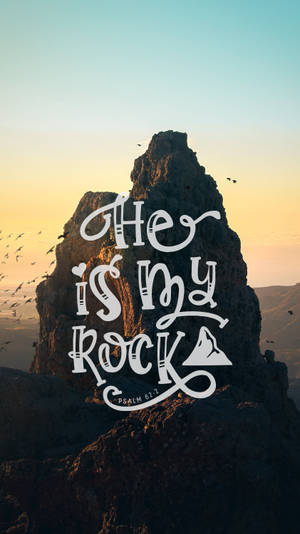一塊大岩石，上面有文字「He is my Rock 詩篇61:2」，背景是日落天空，鳥兒飛翔。 — 神的話語 壁紙