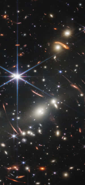 一個充滿星系和恆星的深空視野，帶有鏡頭光暈效果。