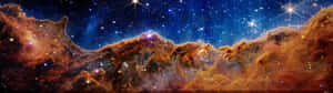 廣闊的宇宙場景，在深藍色太空中充滿發光的星雲和閃爍的星星。 — 32:9 壁紙