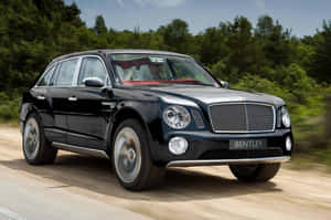 黑色賓利 Bentayga SUV 在森林道路上快速行駛。