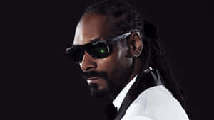 Snoop Dogg 身穿白色西裝和黑色太陽眼鏡，表情自信。 — 說唱歌手 壁紙