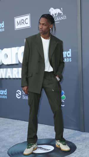 男子在Billboard Awards穿著綠色西裝站在藍色地毯上。