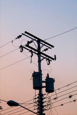 電線杆連變壓器及電線在暮色天空下形成剪影。