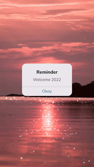 水面上粉紅色的日落，漂浮的數位提醒框寫著歡迎2022。