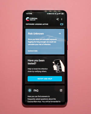 智能手機在粉紅色背景上顯示Corona-Warn-App，並啟用了暴露記錄功能。 — Nokia 壁紙