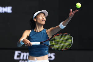 女性網球選手在比賽中發球，神情專注。 — 網球 壁紙