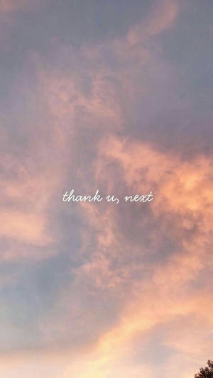 粉彩日落天空，有柔和嘅雲同埋 thank u next 文字