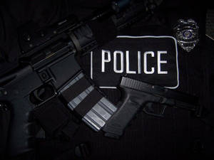 警察步槍手槍和徽章放在帶有警察補丁的制服上。