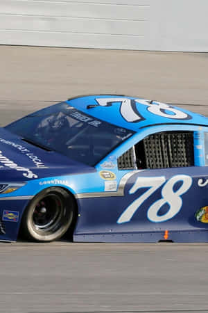 藍白相間的 NASCAR 卡車在賽道上奔馳，帶有動態模糊。