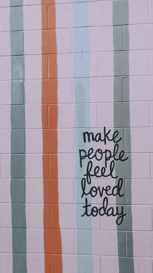 粉彩條紋磚牆，帶有手寫勵志語句 make people feel loved today