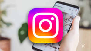 手拿著顯示Instagram應用程式標誌的電話。