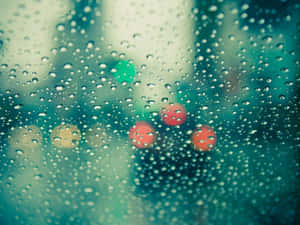 窗戶上的雨滴，模糊的城市燈光在青綠色調中柔和發光。
