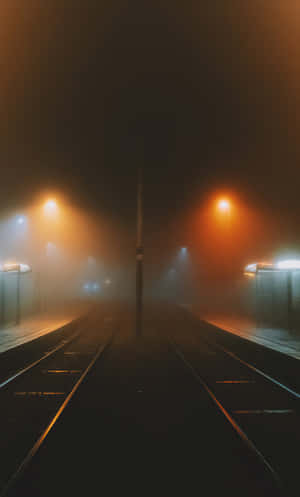 夜晚空無一人的火車站，有霧和發光的街燈。