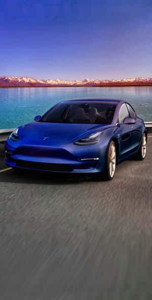 藍色Tesla Model 3在日落時分行駛在海岸公路上，背景有山脈和水。