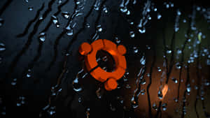 Ubuntu標誌在雨窗上，帶有發光的橙色光和水滴。