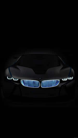 黑色BMW概念車在黑暗中亮起藍色車頭燈的正面視圖。