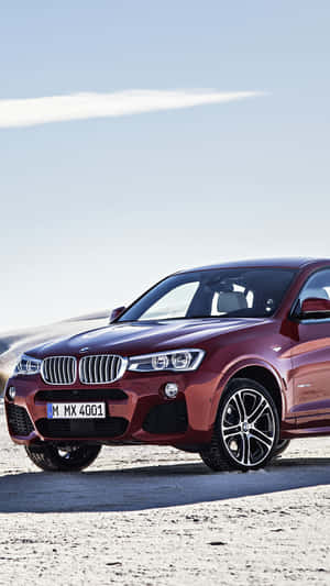 紅色BMW X4 SUV停泊在沙漠公路，夕陽西下