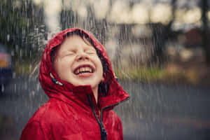 孩子穿著紅色連帽外套在雨中大笑