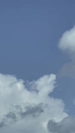 藍天白雲，遠處有飛機尾跡。