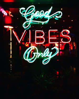 夜間以紅色和藍綠色燈光顯示 Good Vibes Only 的霓虹燈牌。