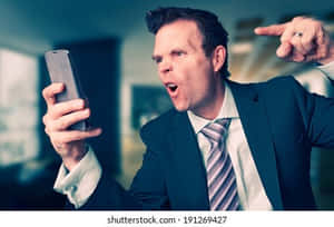 憤怒的商人在辦公室對著智能手機大喊