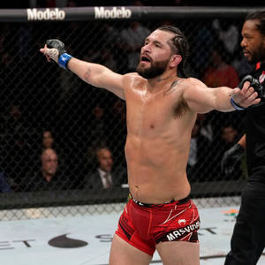 MMA拳手在八角籠中舉臂慶祝勝利。 — 運動 壁紙