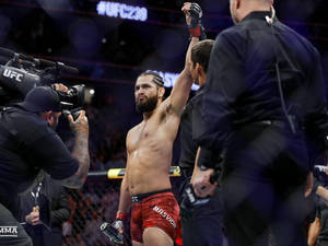UFC拳手在八角籠內舉拳慶祝勝利。