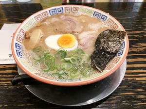 冒煙的拉麵，配有蛋、青蔥和紫菜在木桌上