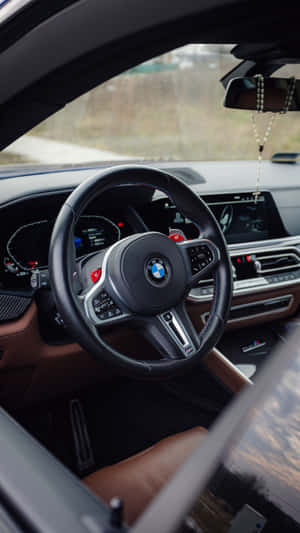BMW M 車內裝，黑色皮革方向盤和數位儀表板。 — 9:16 壁紙