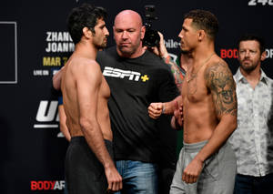 兩名男性MMA拳手在UFC稱重活動中與裁判和攝製組互相凝視。 — 運動 壁紙