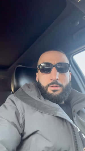 留鬍鬚戴太陽眼鏡的男人在車內穿灰色外套