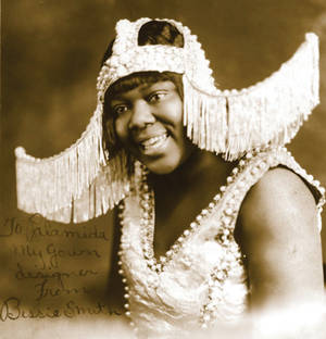 穿著1920年代Flapper服裝的黑人女性微笑對著鏡頭，手持手寫便條。 — 復古 壁紙