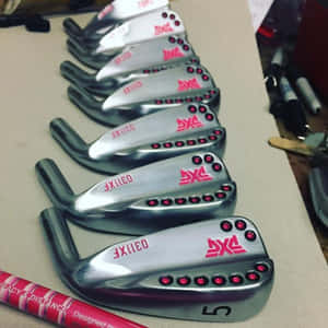 PXG 高爾夫鐵桿帶有紅色點綴，整齊排列在工作台上。