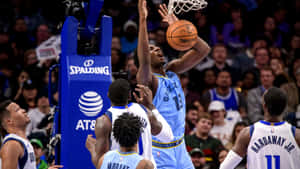 籃球運動員在擁擠的場館中越過防守球員灌籃。 — 科比· Bryant 壁紙