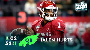 美式足球四分衛Jalen Hurts身穿紅色球衣，在選秀活動中拿著橄欖球。